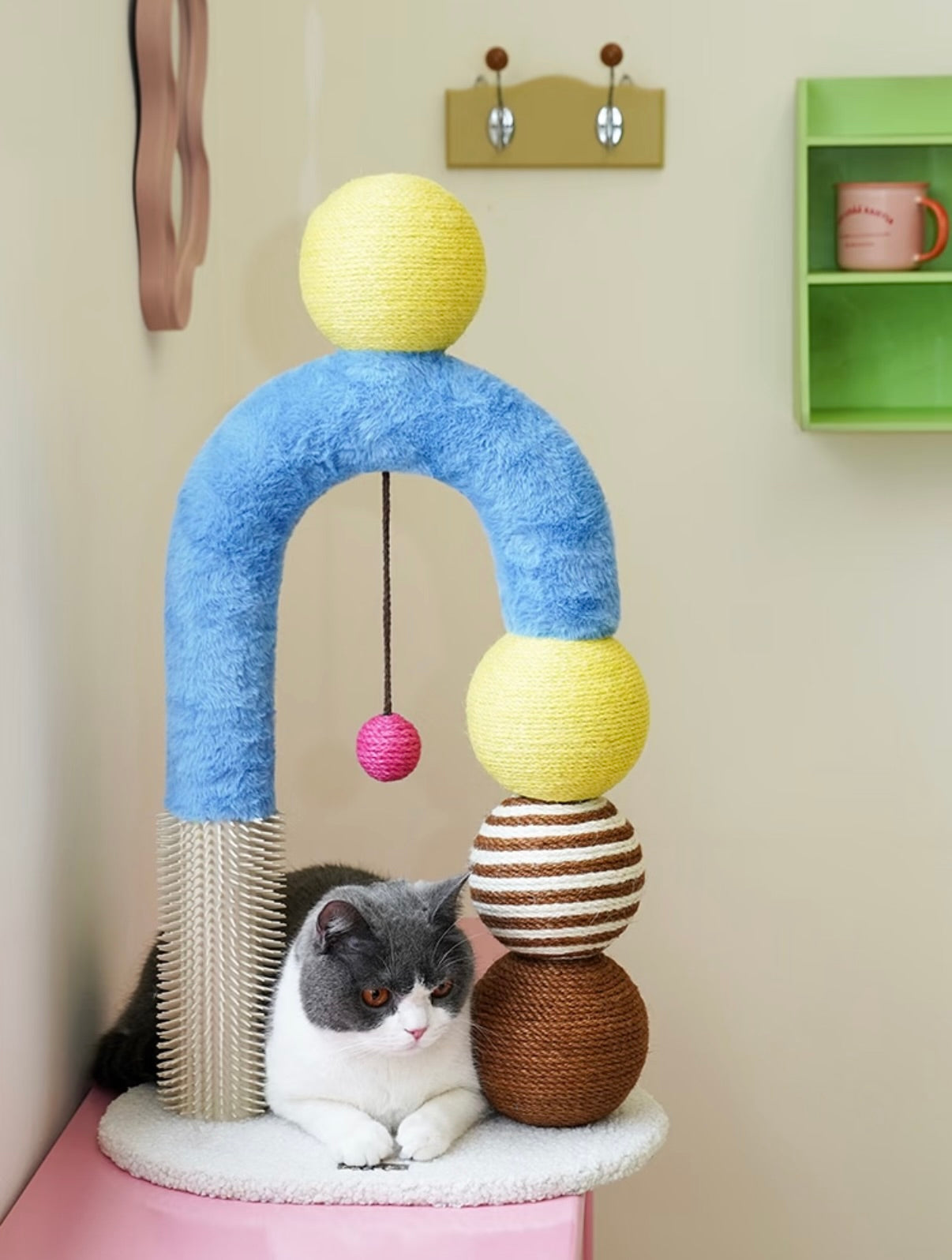 Modern cat arch tree with sisal scratchers, grooming pole, and toys for scratching and play.